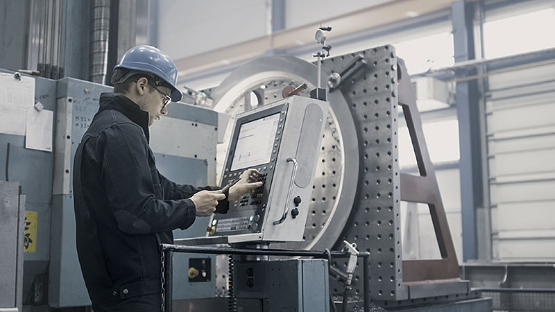 Fabrikarbeiter ist die Programmierung einer CNC-Fräsmaschine mit einem Tabletcomputer