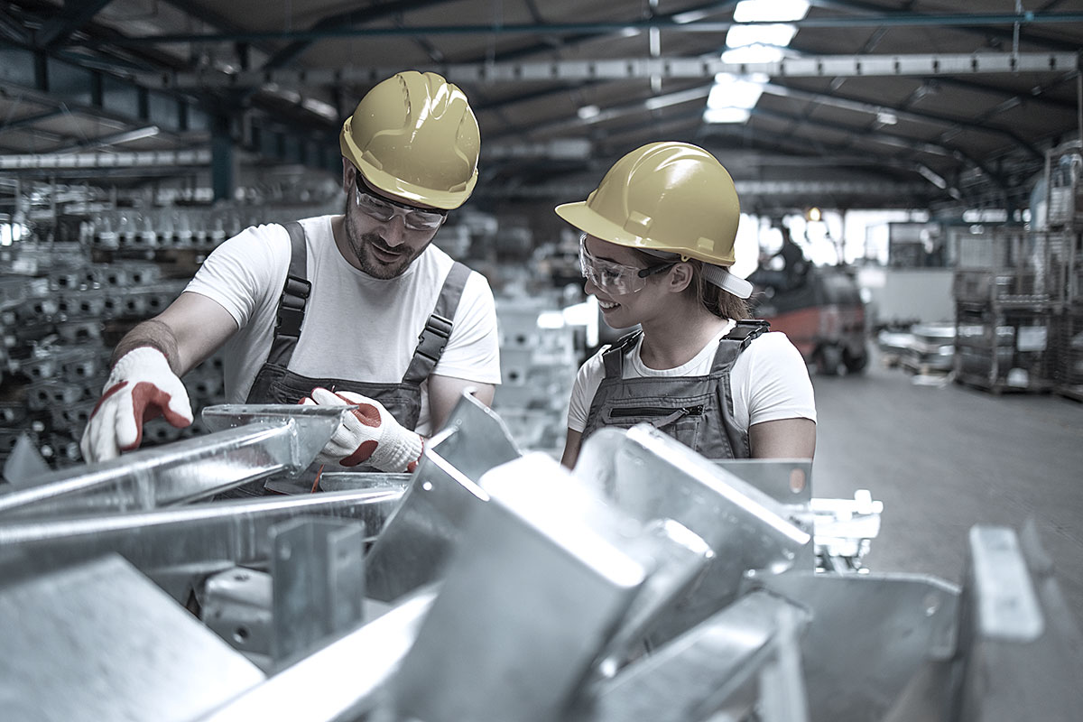 Fabrikarbeiter überprüfen die Qualität von Industriemetallteilen